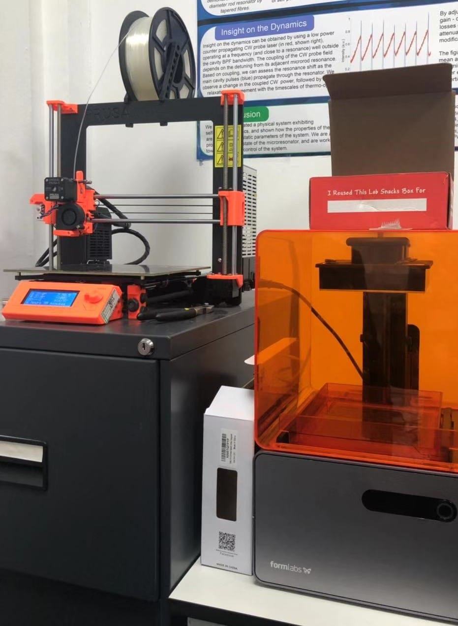 An FDM printer and an SLA printer side by side.