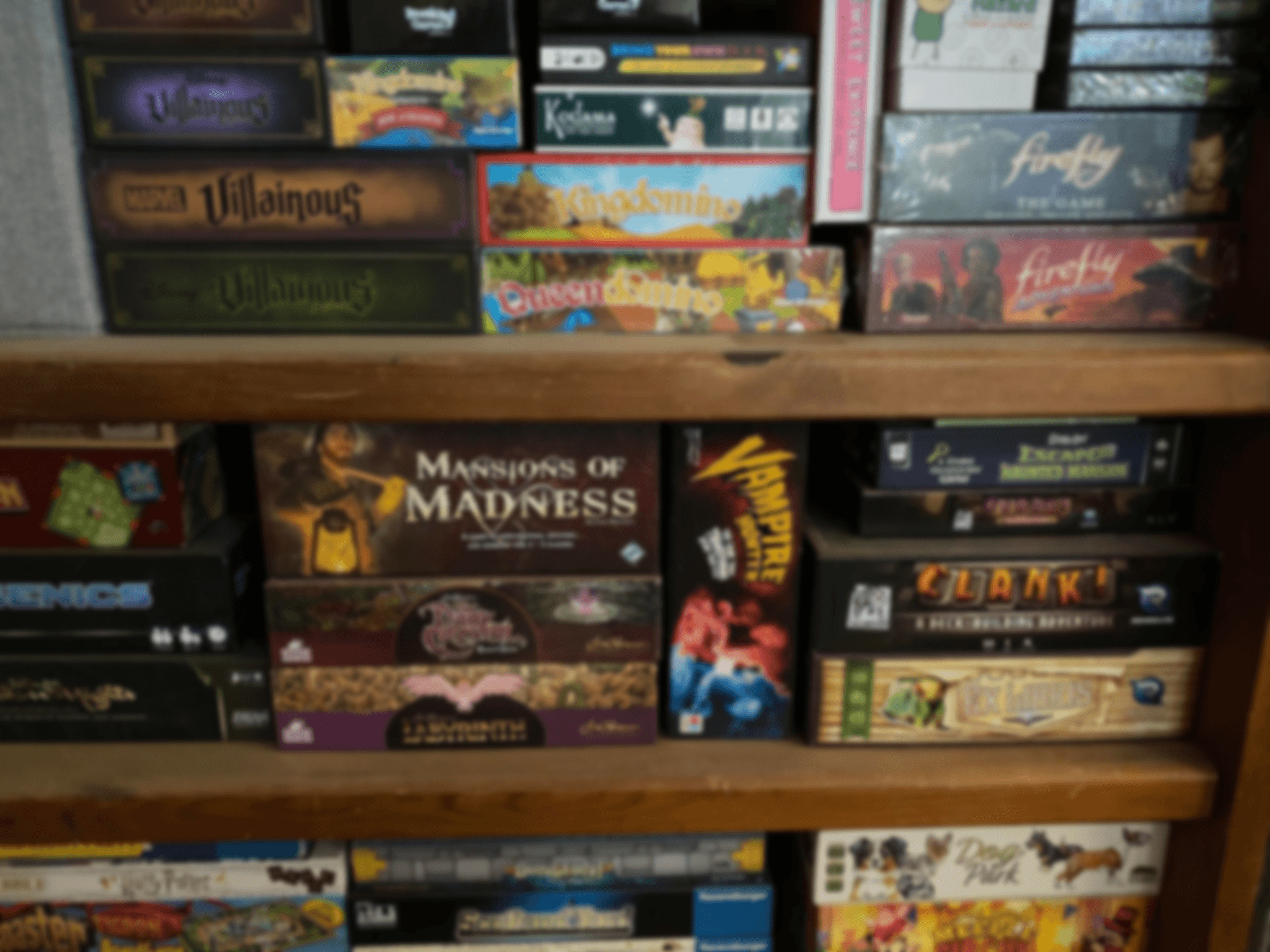 Several shelves full of various boardgames, blurred