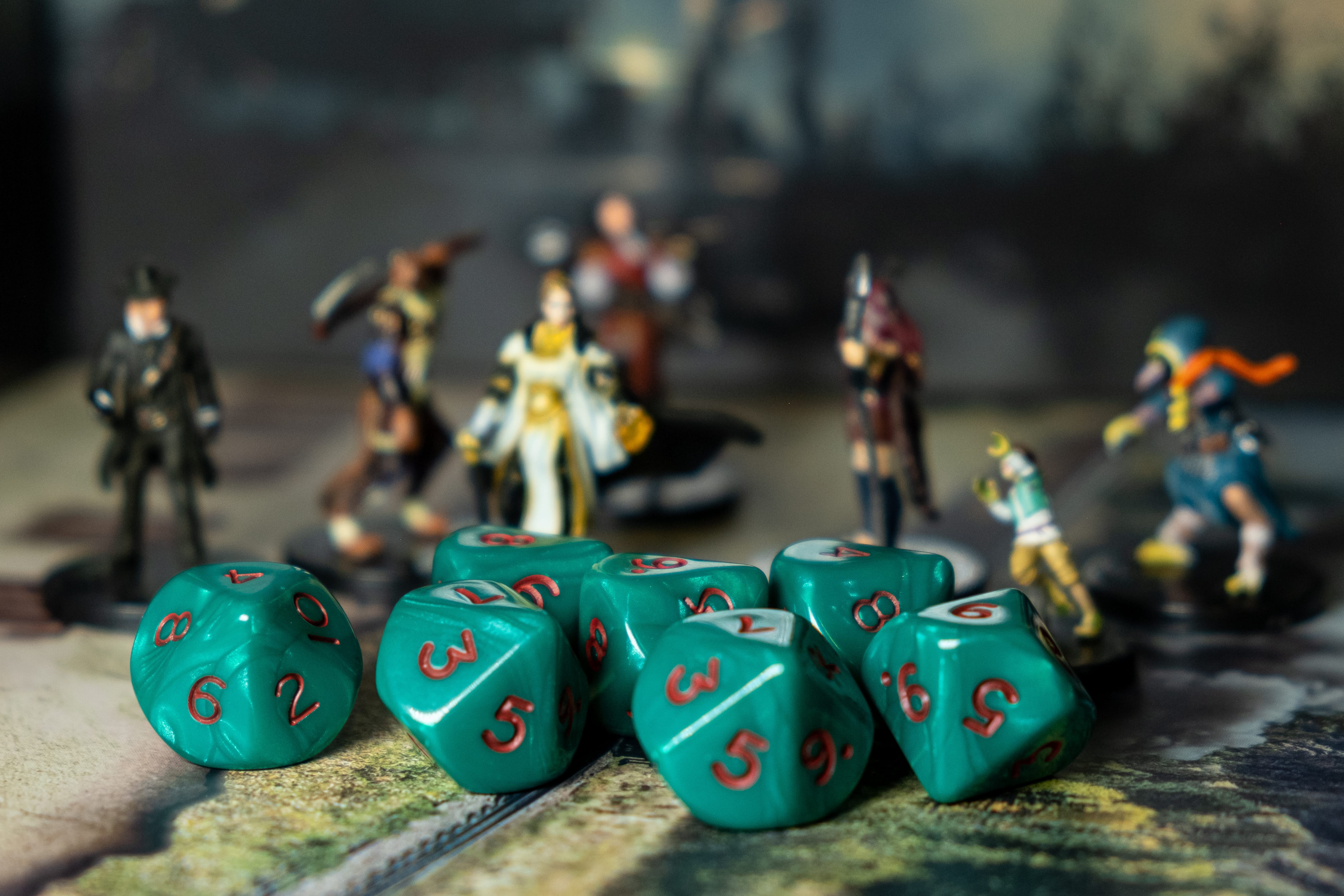 A set of 7 Dice for tabletop gaming in front of a group of minis